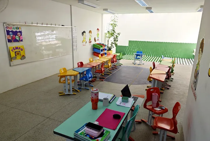 Sala da Educação Infantil com mesas e cadeiras coloridas